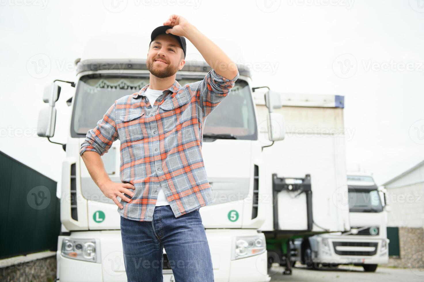Portrait of trucker standing by his truck ready for driving. Driver occupation. Transportation services photo