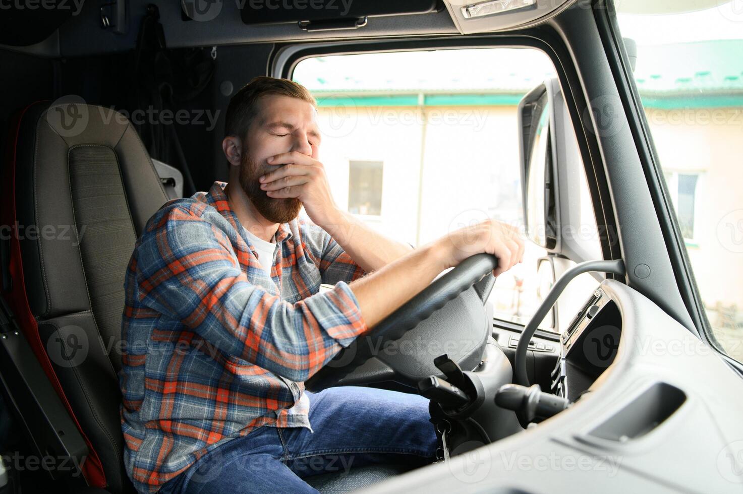 Young truck diver feeling tired and yawning during the ride. photo