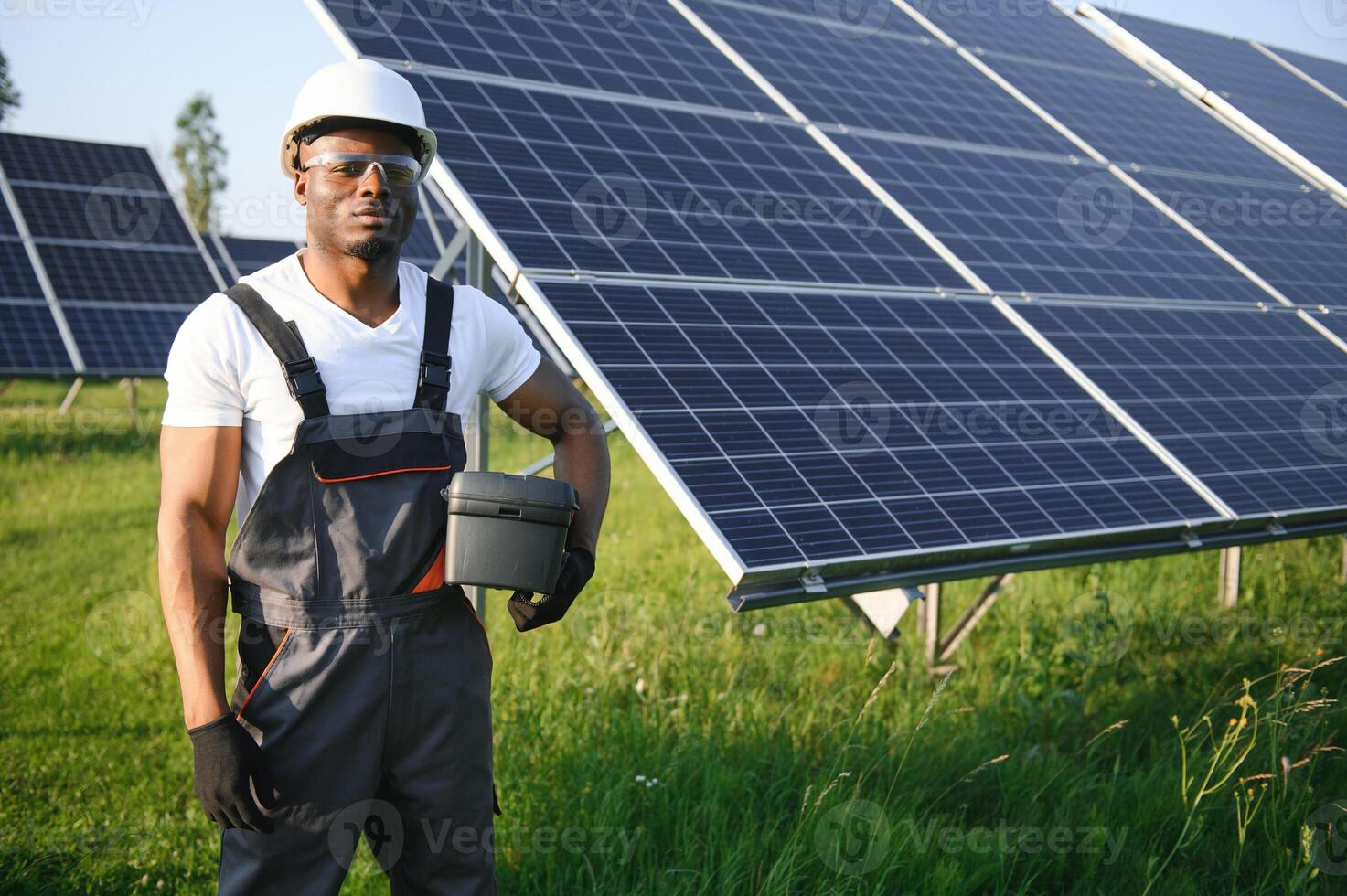 retrato de africano americano electricista ingeniero en la seguridad casco y uniforme instalando solar paneles foto