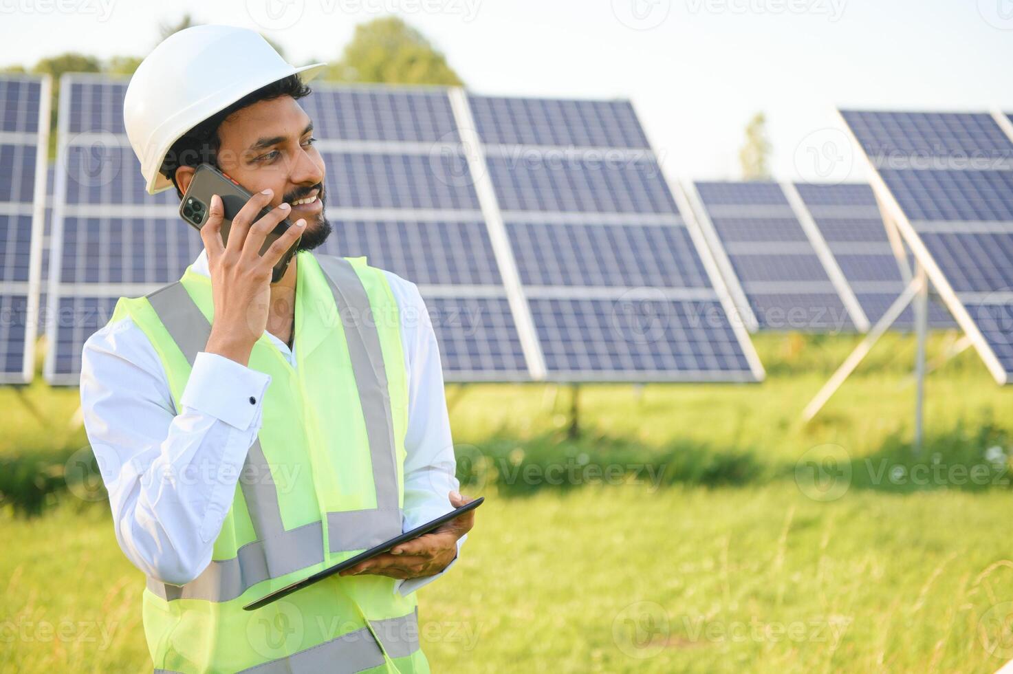 Portrait of Young indian male engineer standing near solar panels, with clear blue sky background, Renewable and clean energy. skill india, copy space. photo