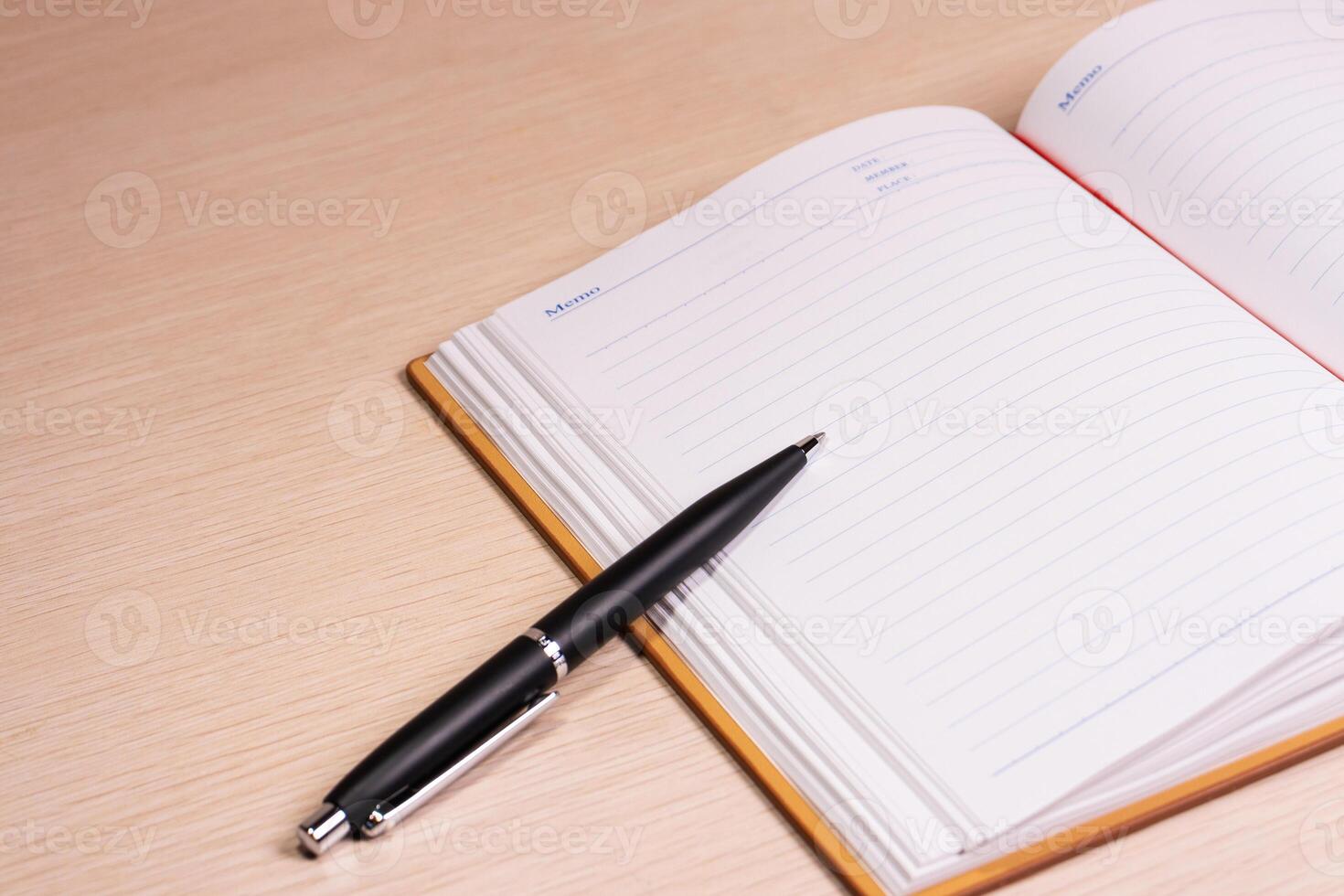 Opened book and pen on a desk. After some edits. photo