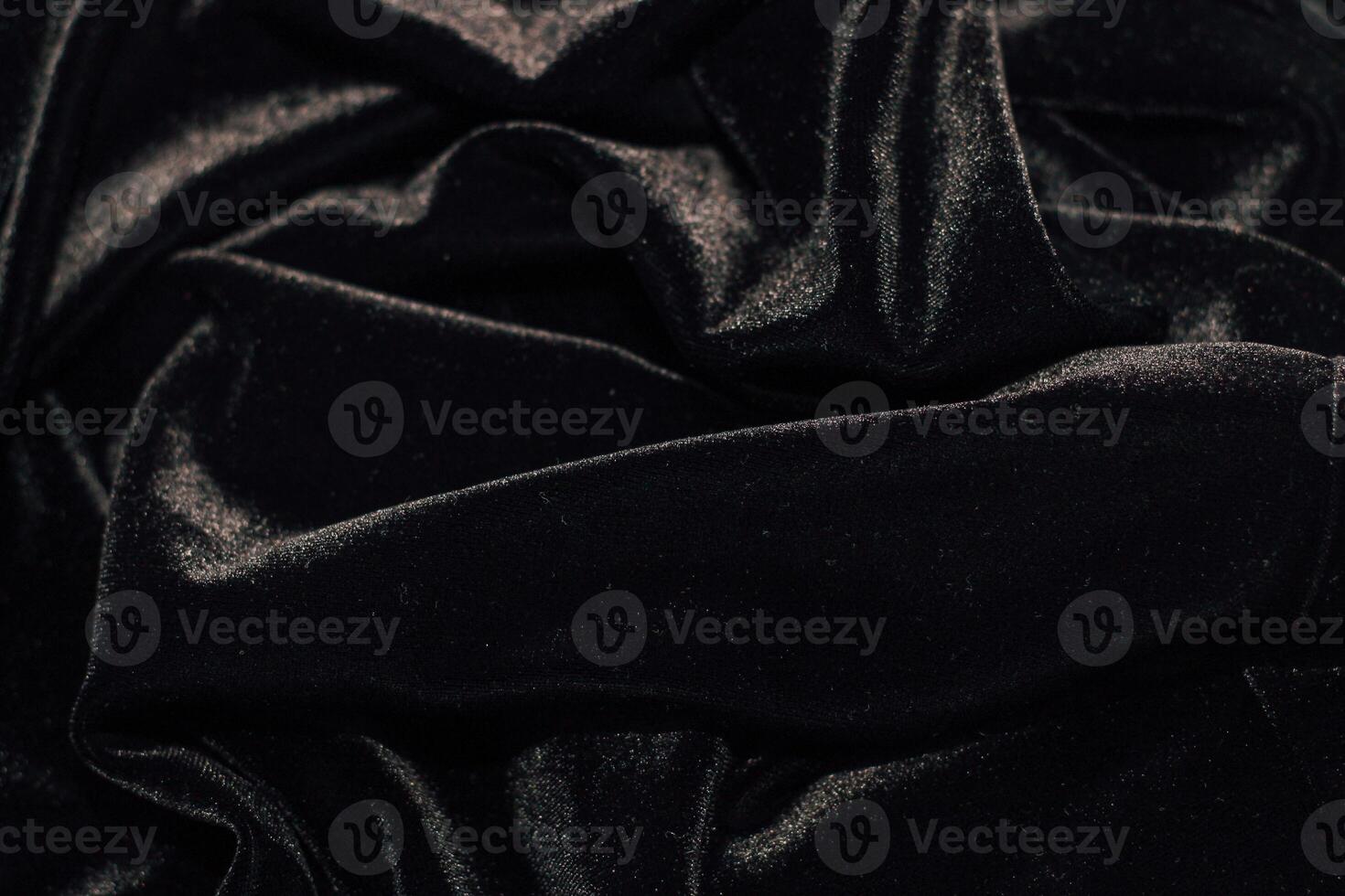 Texture of black velor corduroy fabric with folds. photo