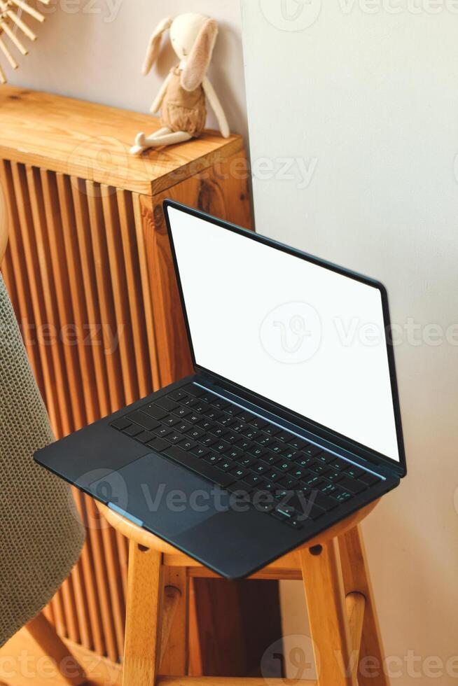A thin laptop working computer stands on a stylish chair in the interior. photo