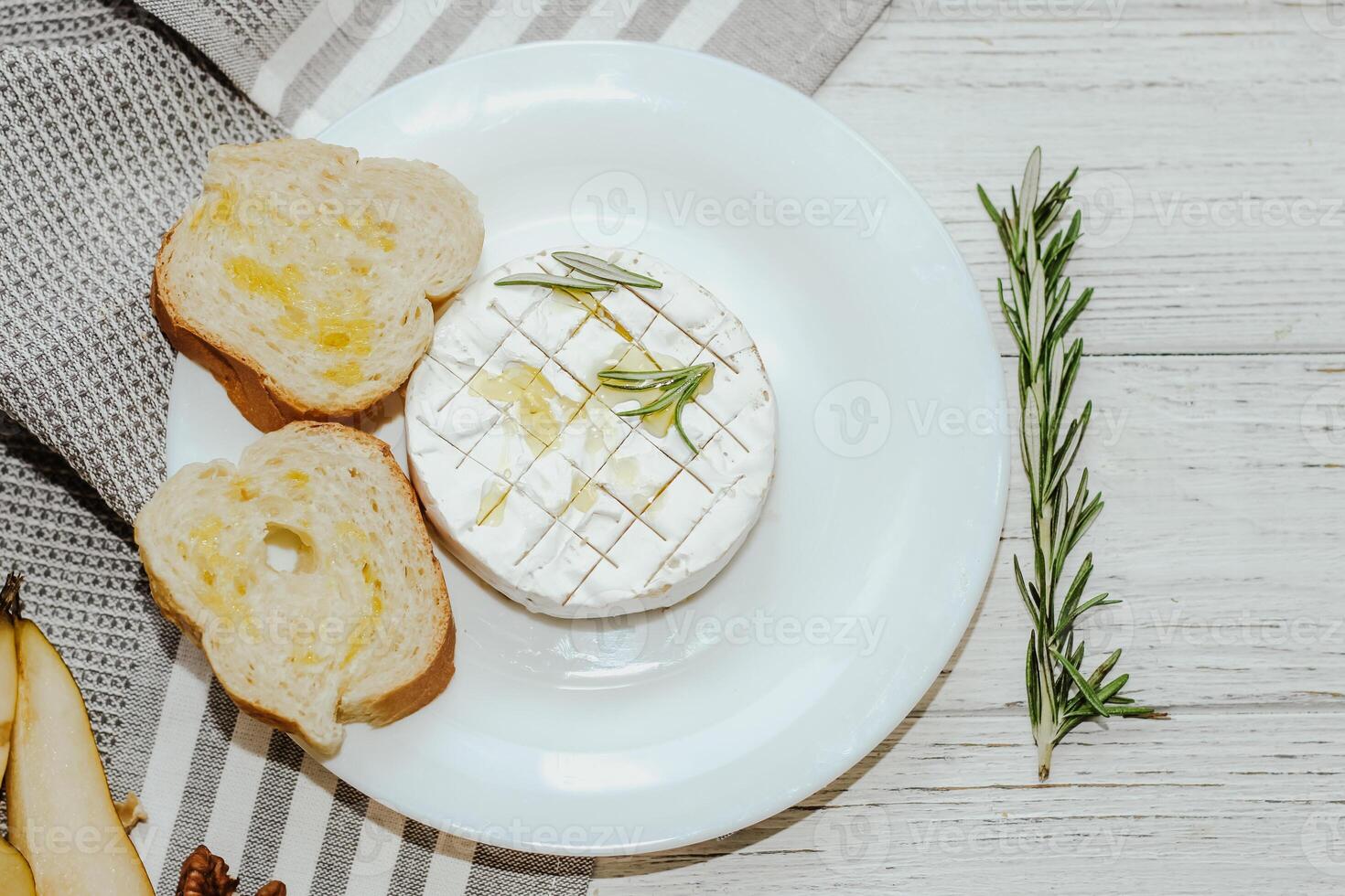 White baguette cut into pieces with olive oil and Camembert cheese on the table. photo