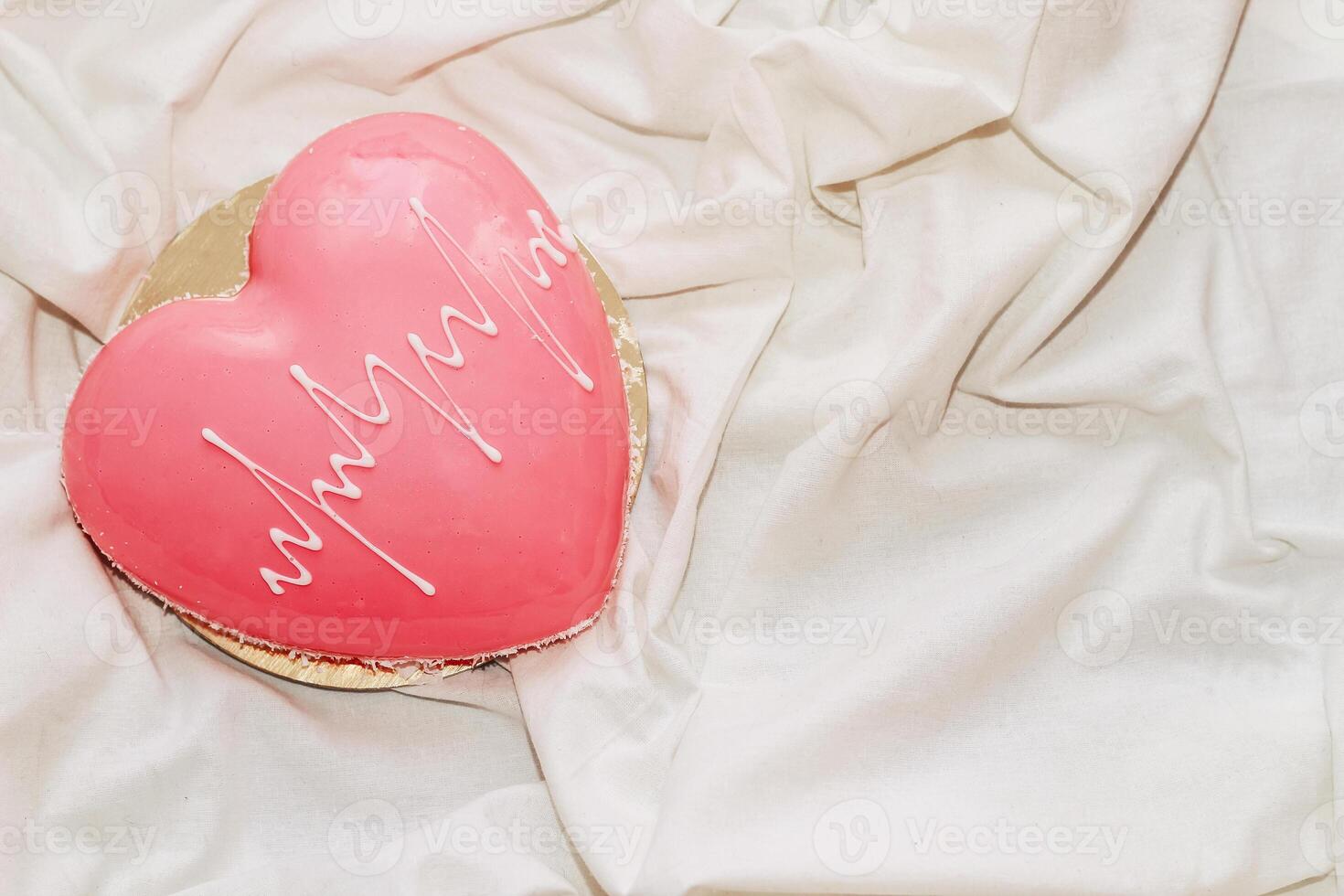 Heart shaped pink mousse cake on the table. photo