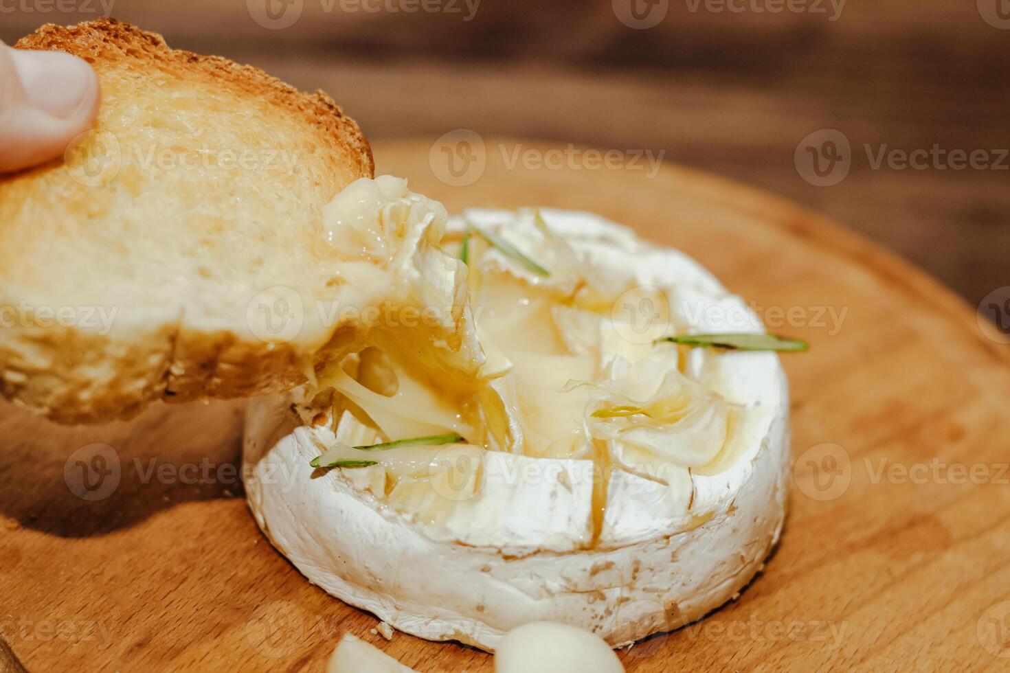 White baguette with olive oil and baked Camembert cheese on the table. photo