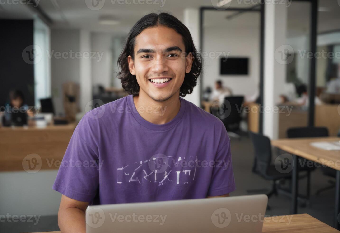 AI Generated A relaxed young man with a laptop is smiling and looking at the camera. The setting is a busy office with other professionals. photo