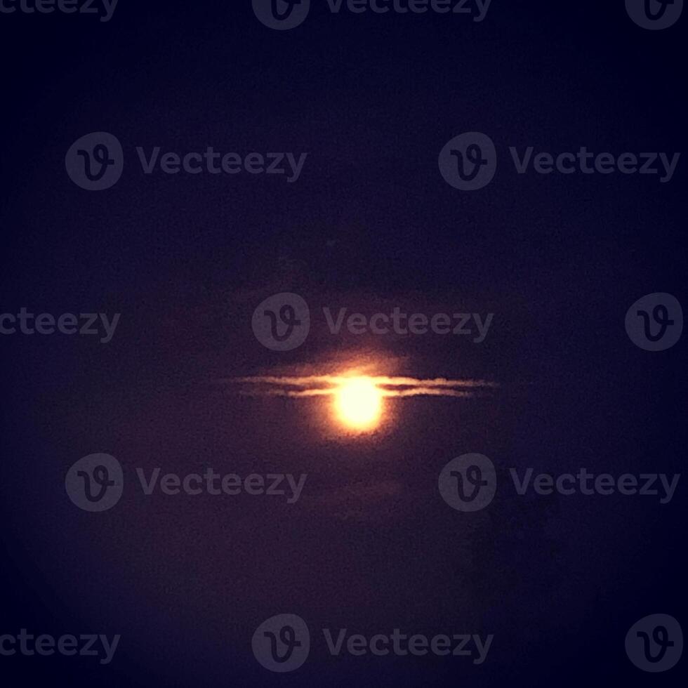 The sun sets behind the clouds in the sky. Toned. photo