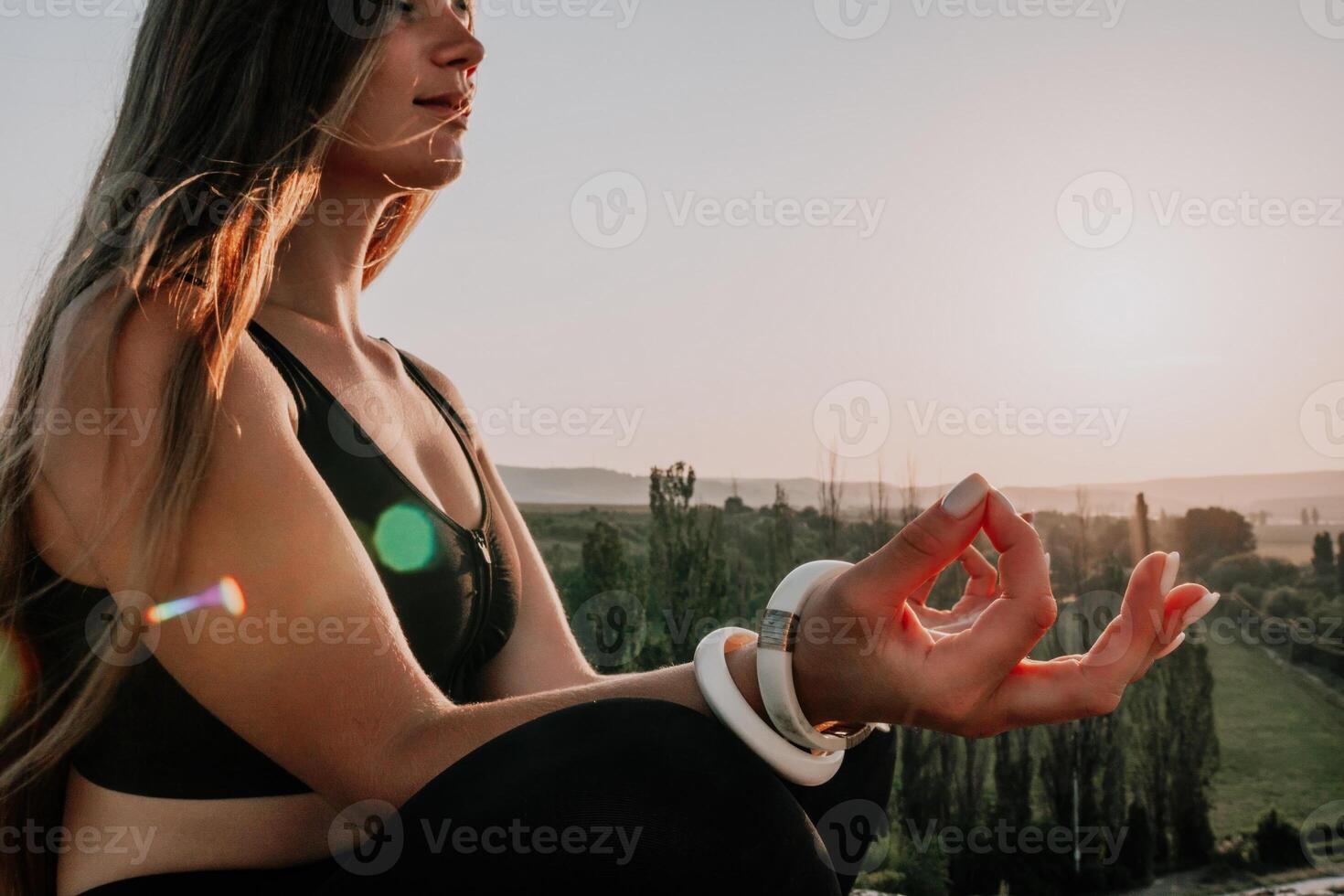 Fitness woman. Well looking middle aged woman with long hair, fitness instructor in leggings and tops doing stretching and pilates on the rock near forest. Female fitness yoga routine concept. photo