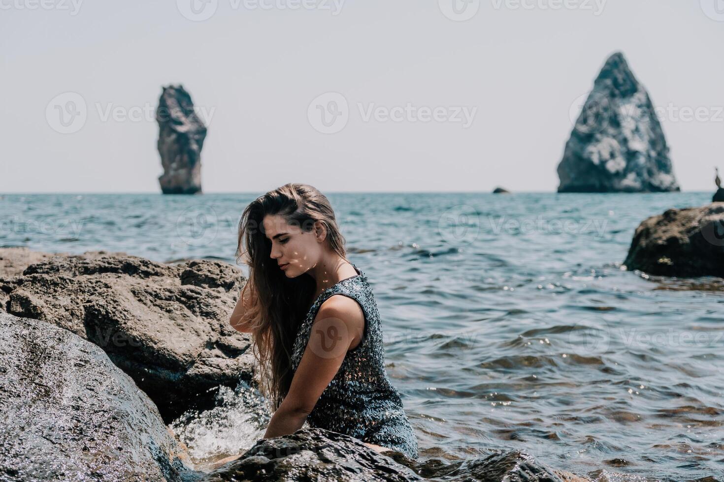 Woman summer travel sea. Happy tourist enjoy taking picture outdoors for memories. Woman traveler posing on the beach at sea surrounded by volcanic mountains, sharing travel adventure journey photo