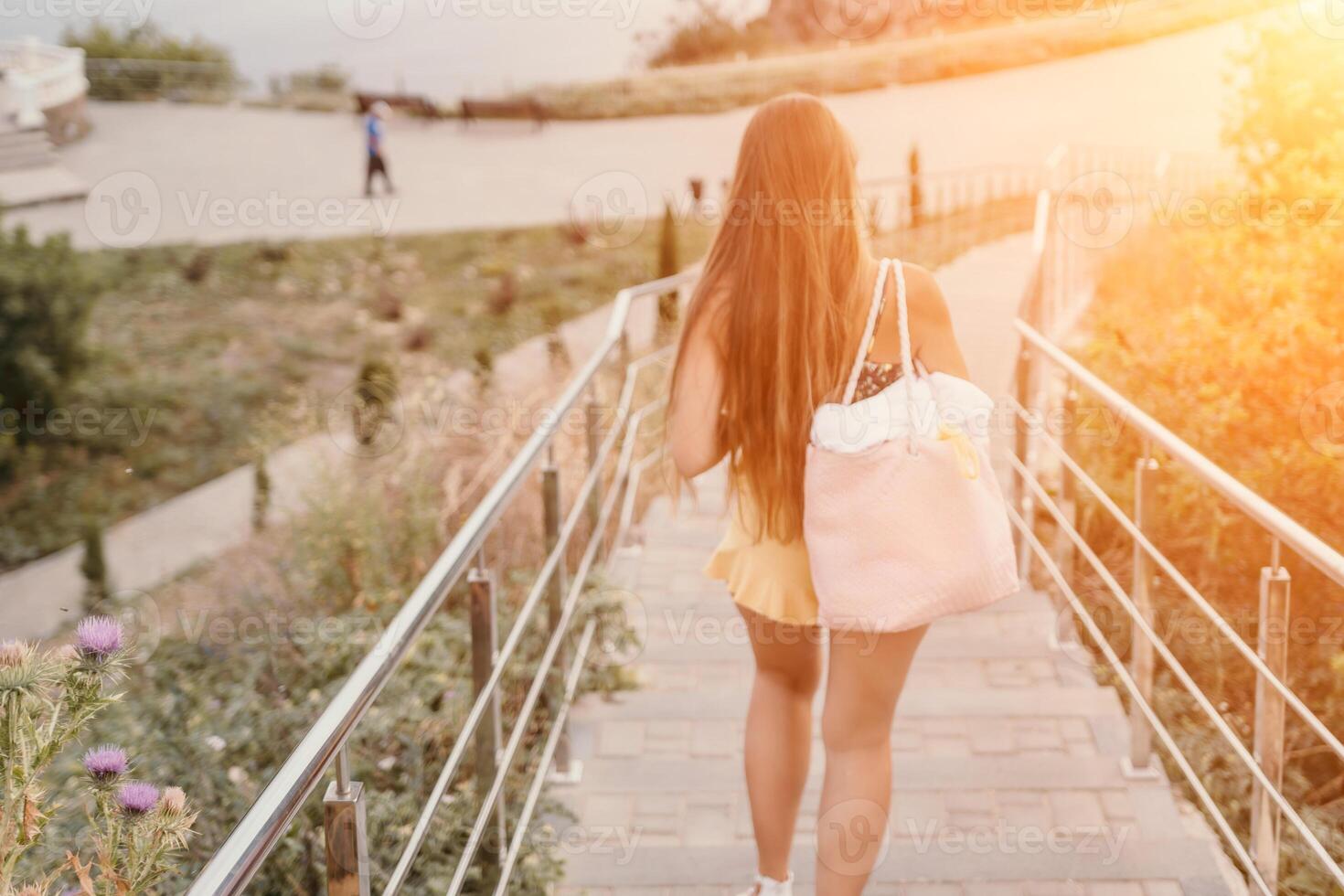 Woman travel sea. Happy tourist enjoy taking picture outdoors for memories. Woman traveler looks at the edge of the cliff on the sea bay of mountains, sharing travel adventure journey photo