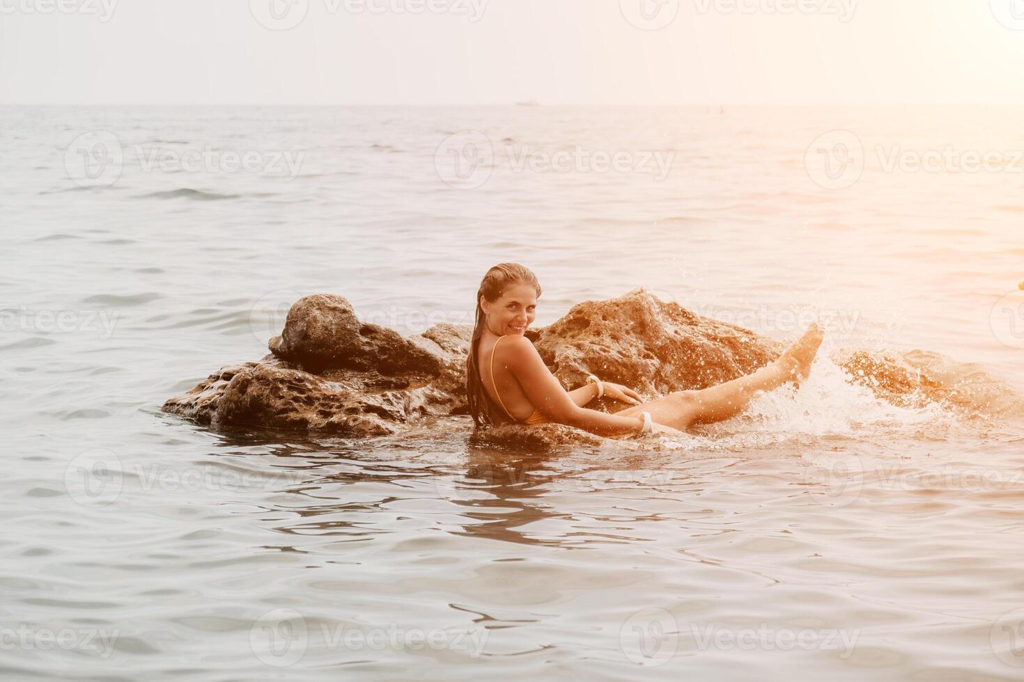 mujer viaje mar. contento turista en sombrero disfrutar tomando imagen al aire libre para recuerdos. mujer viajero posando en el playa a mar rodeado por volcánico montañas, compartiendo viaje aventuras viaje foto