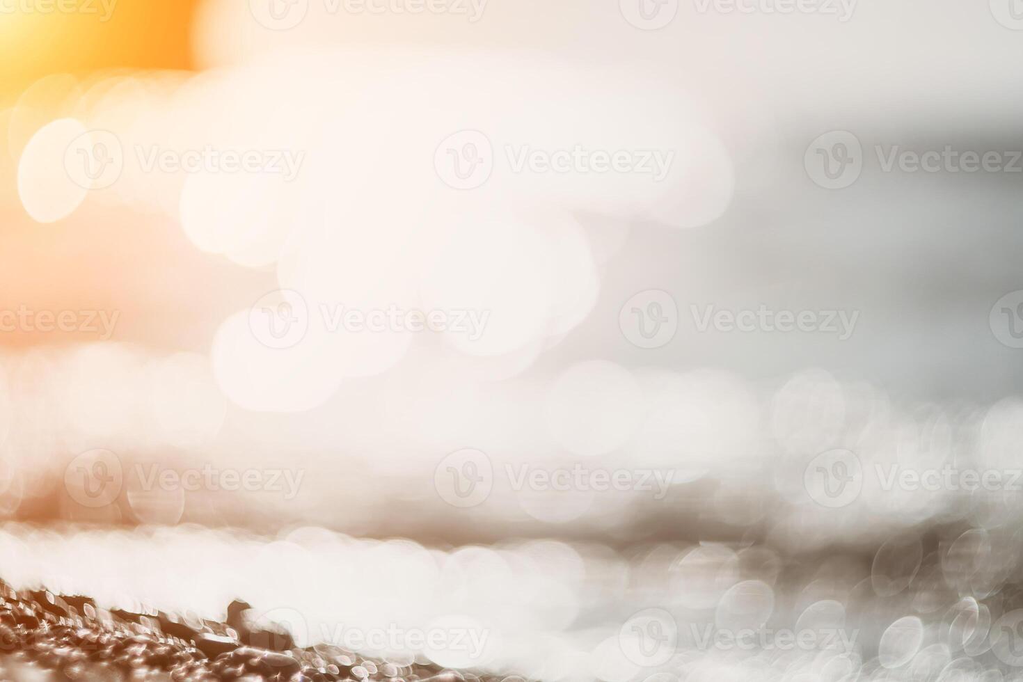 Blurred golden sea at sunset. The sun reflects and sparkles on the waves with bokeh, illuminating the golden sea. Holiday recreation concept. Abstract nautical summer ocean sunset nature background. photo