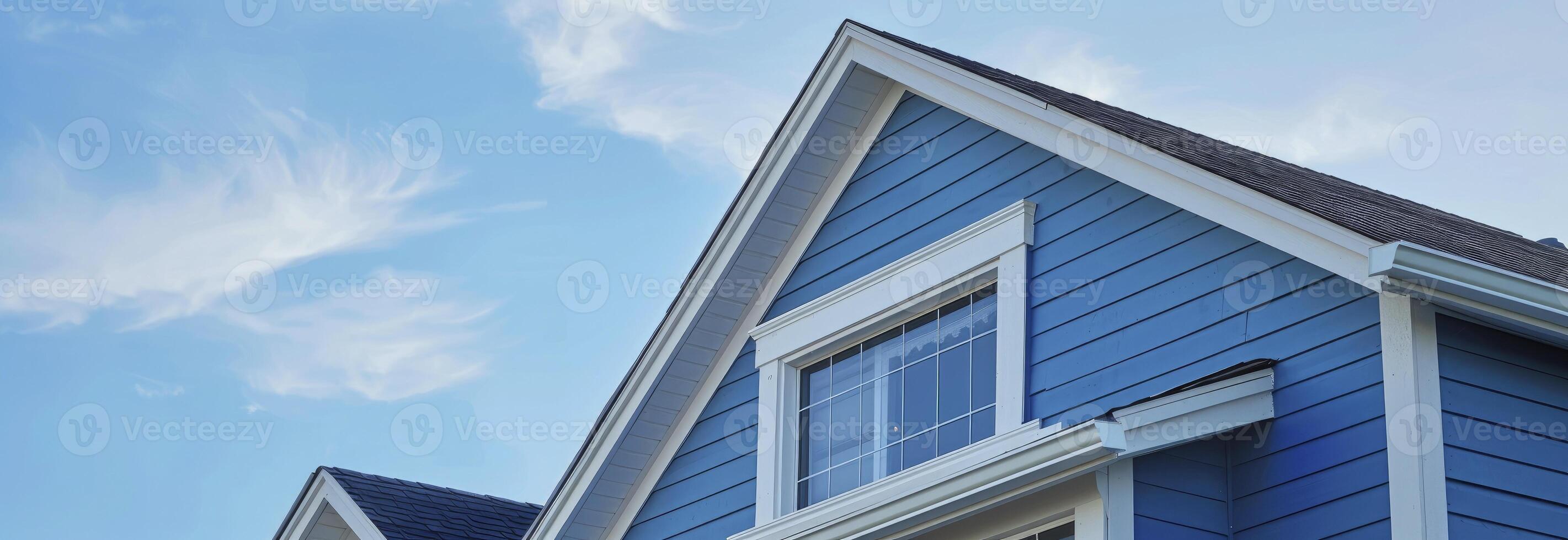 AI generated The top roof and gable on a blue house with white trim, against a blue sky background. photo