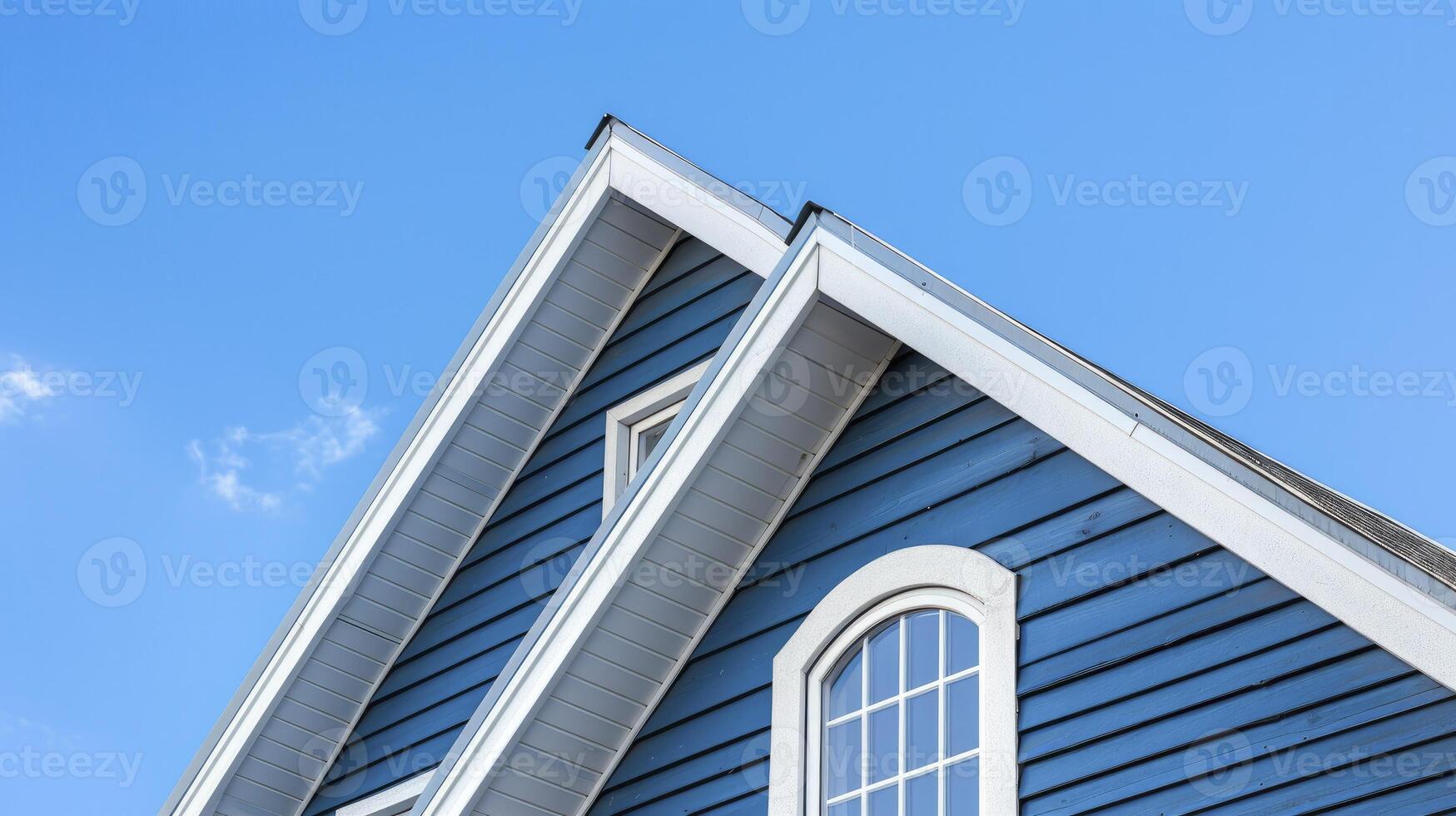 AI generated The top roof and gable on a blue house with white trim, against a blue sky background. photo