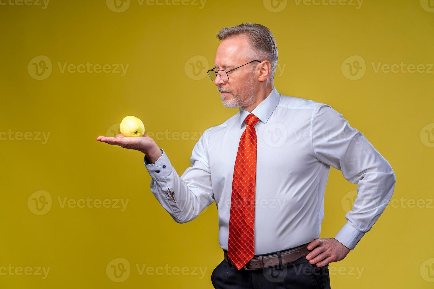 Portrait of attractive man posing on camera. Holding yellow apple in hand. Isolated over white background. photo