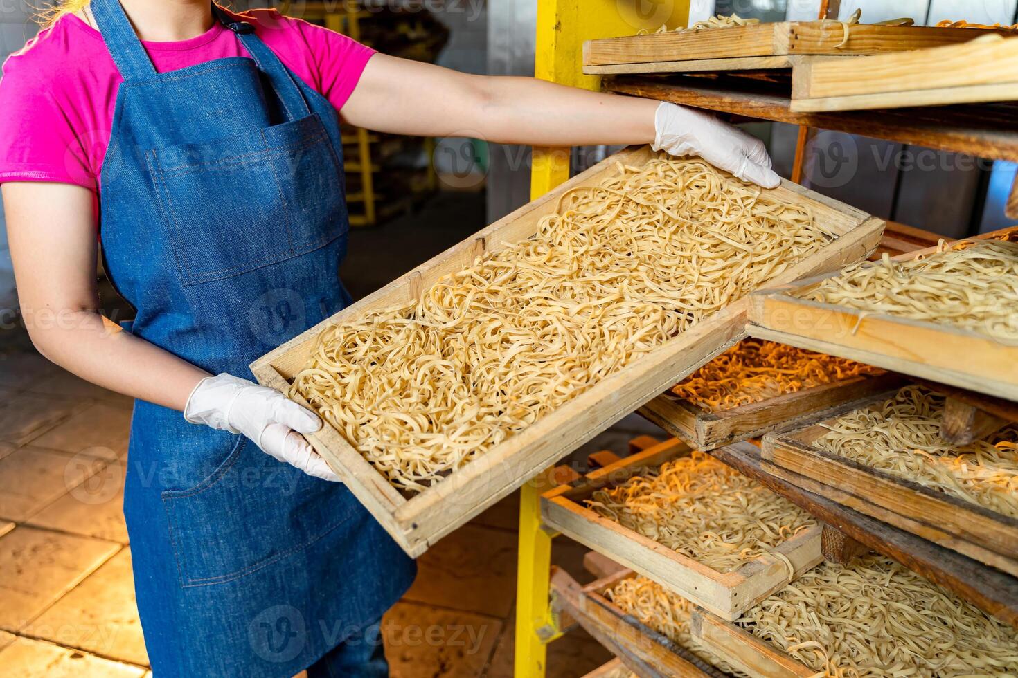 pasta fábrica. producción de pasta. kraft macarrones. trabajador con de madera caja con pasta. foto