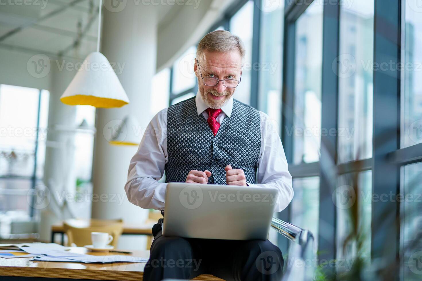 Senior man sits happy with laptop on knees. happy emotions and good news. photo