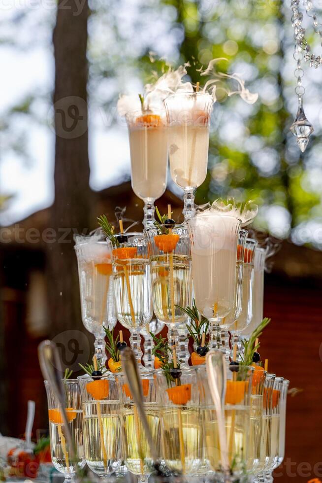 Glass of champagne for event party or wedding ceremony. Pyramid of glasses of champagne for celebrate in party with blurred background. Champagne tower. photo