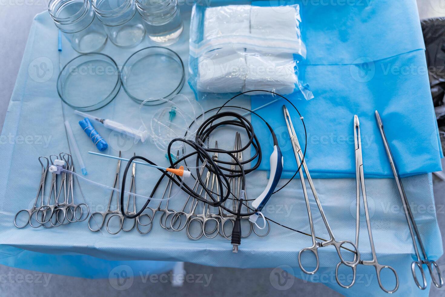 Surgical instruments and tools including scalpels, forceps and tweezers. Arranged surgery tools on a table in operating room. photo