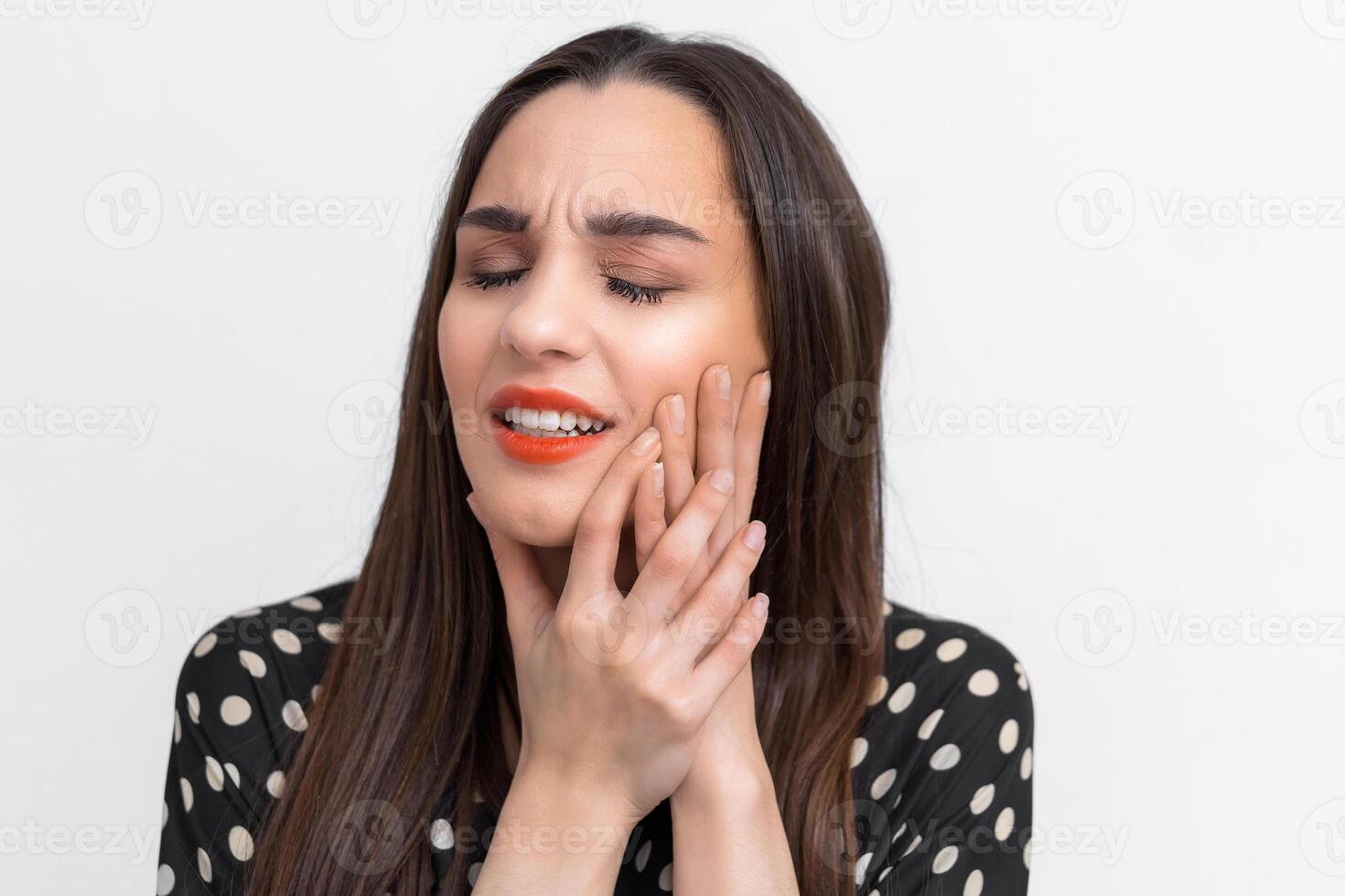 Suffering from toothache. Beautiful young woman suffering from toothache, standing against white background. Dental care concept. People emotions. photo