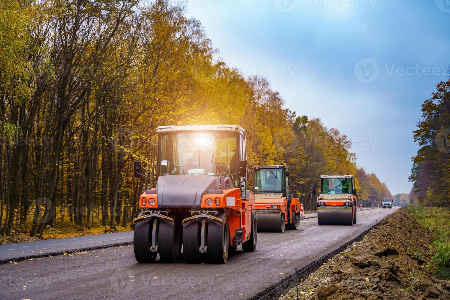 Three road rollers flattering new asphalt. New road. Freshly paved asphalt. photo