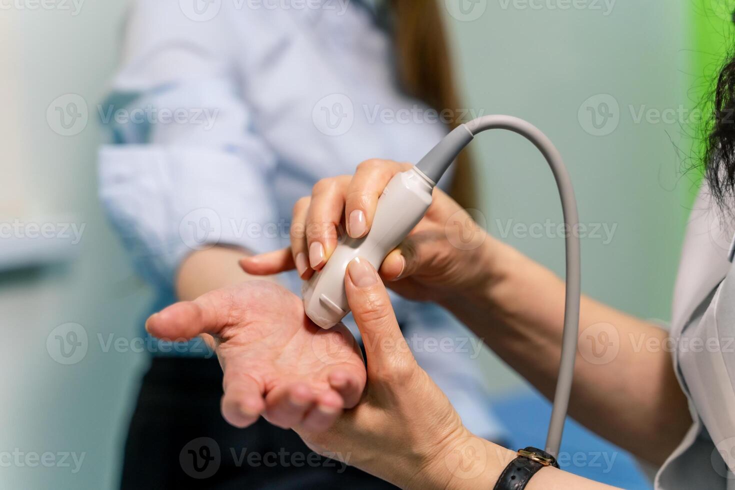 Midsection of radiologic technician scanning female patient's hand photo