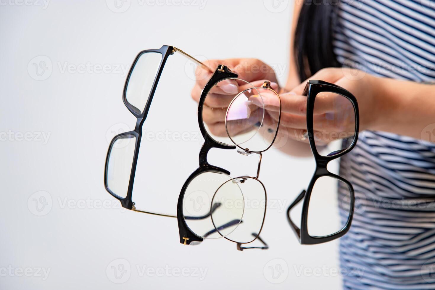 Eyeglasses closeup. Spectacles in woman's hands. Many glasses. Front view. Zoom in. photo