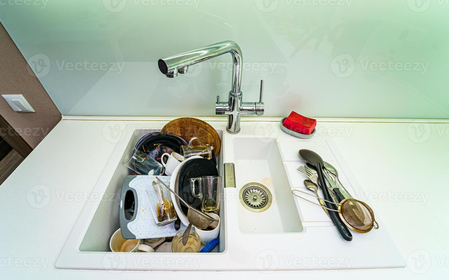 Pile of dirty dishes in white sink. View from above. photo