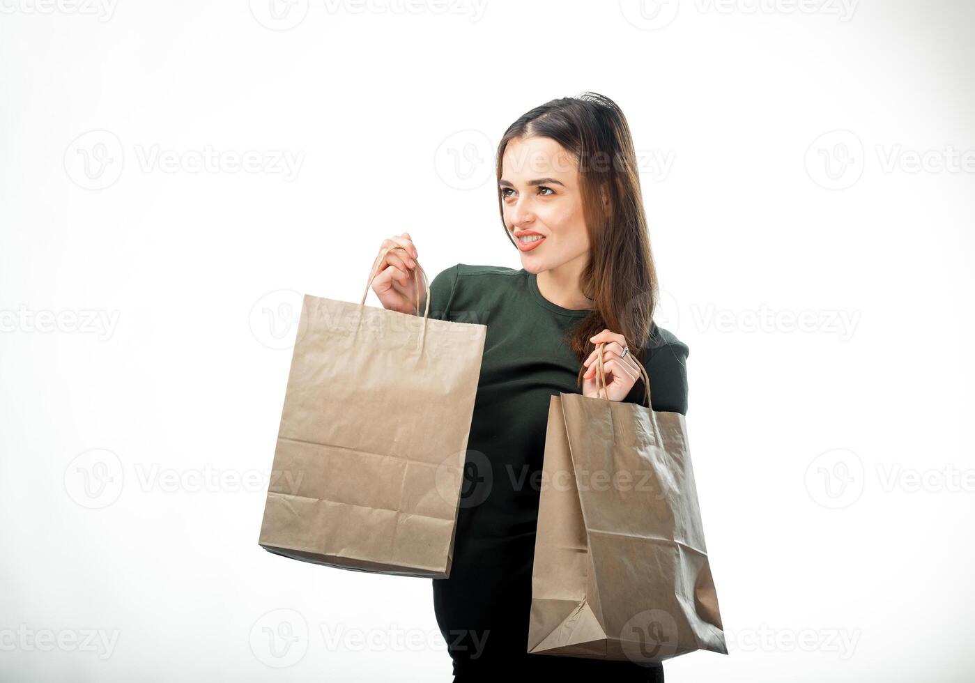Woman is holding two grocery shopping bags on white background. Paper bags in hands. Isolated background. photo