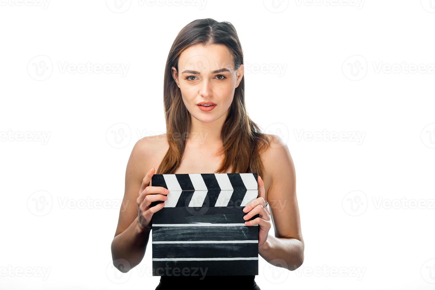 Girl with film numerator standing on white background. Clapper board in hands of beauty. photo