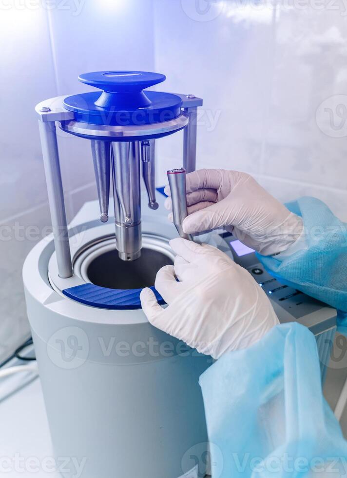 hembra enfermero haciendo esterilización de dental médico instrumentos en autoclave. esterilización Departamento a dental clínica foto