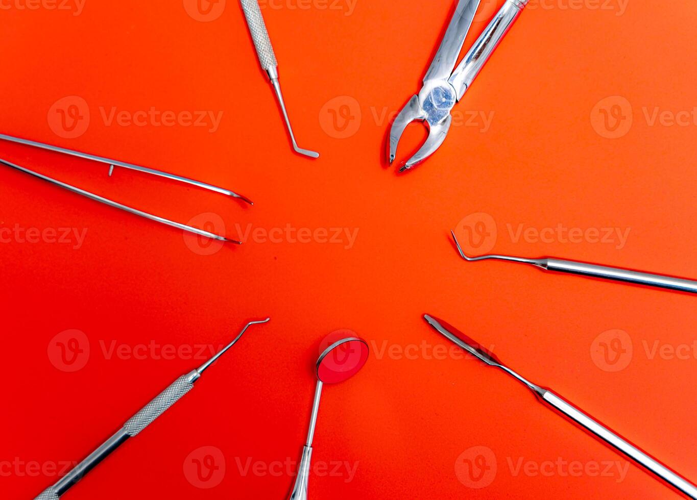 Dental set, mirror, probe. Concept care. Instruments isolated on red background. photo