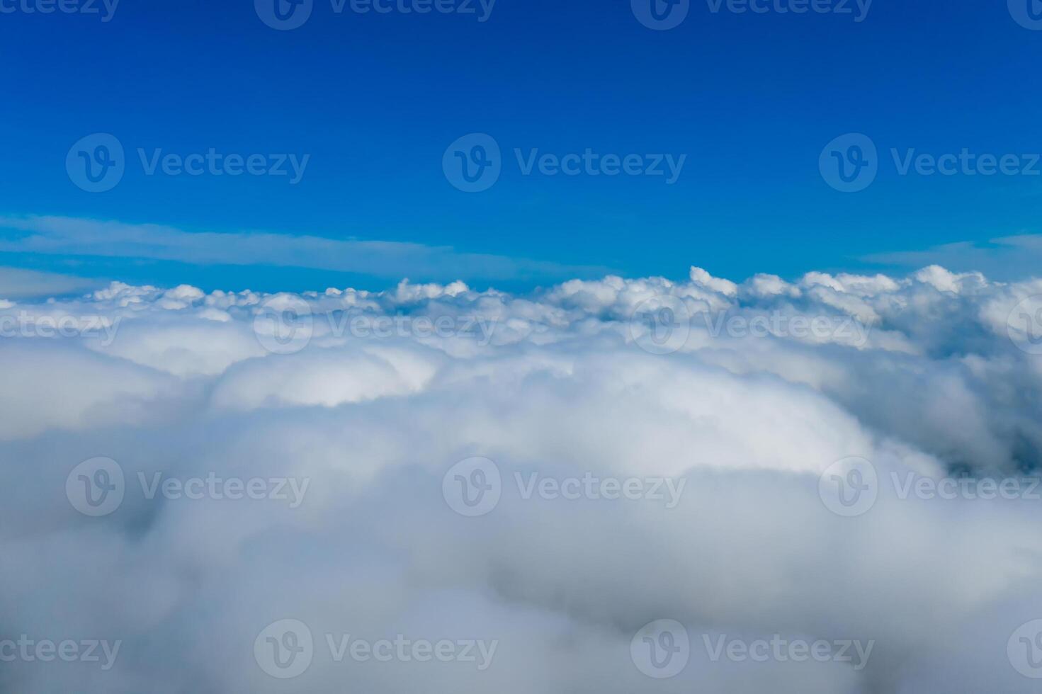 Light clouds seen from airplane. Blue endless sky above fluffy clouds. photo