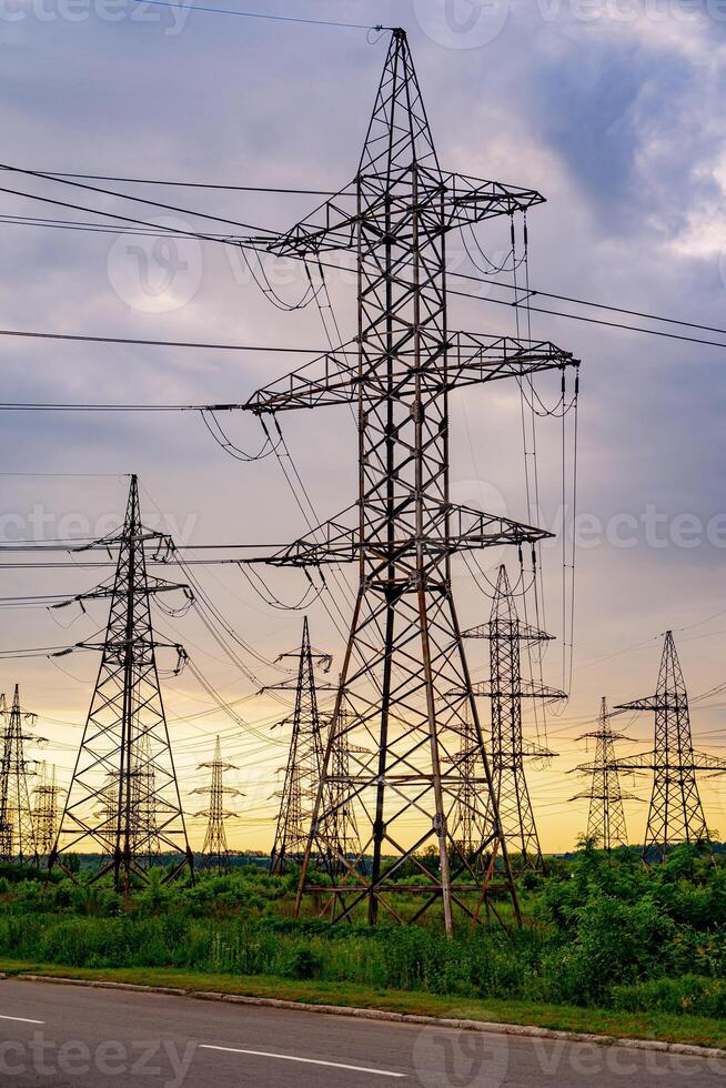 High voltage electric tower. Silhouette on sunset time. Power pylons on sunset time background. Selective focus photo