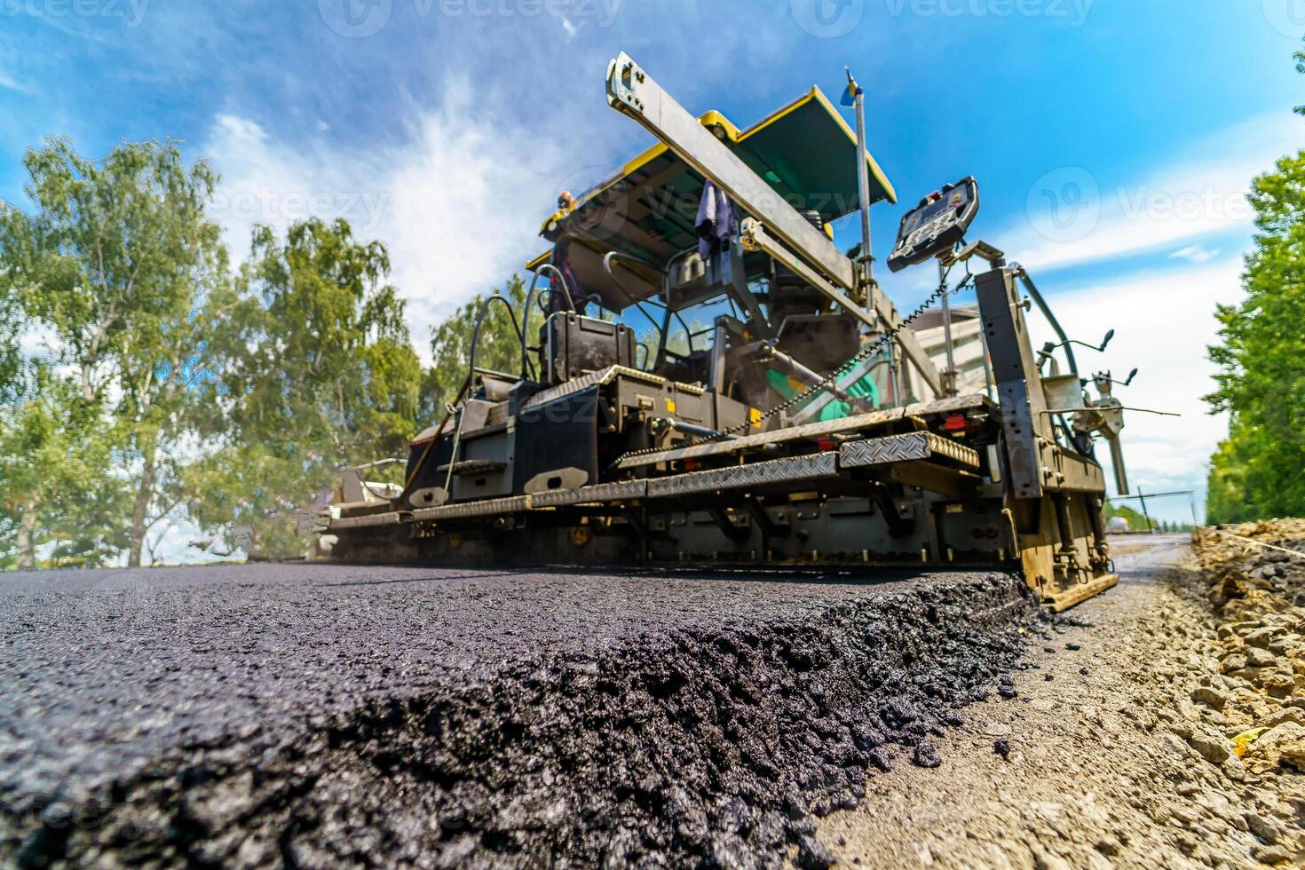 Selective focus on newly laid asphalt. Heavy special technic for flattering asphalt at road. Construction site. photo