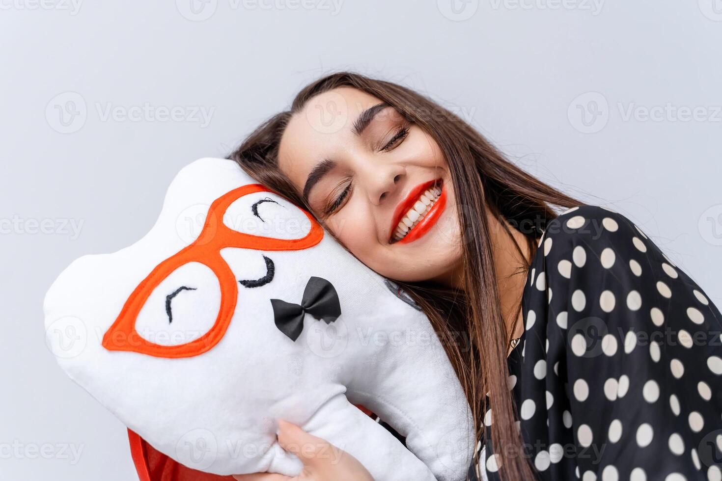 Young beautiful girl closed eyes and laid head on soft toy in shape of tooth. photo