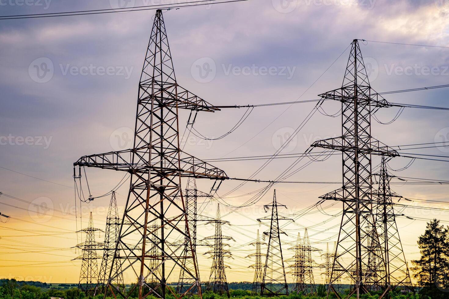 High voltage electric tower. Silhouette on sunset time. Power pylons on sunset time background. Selective focus photo