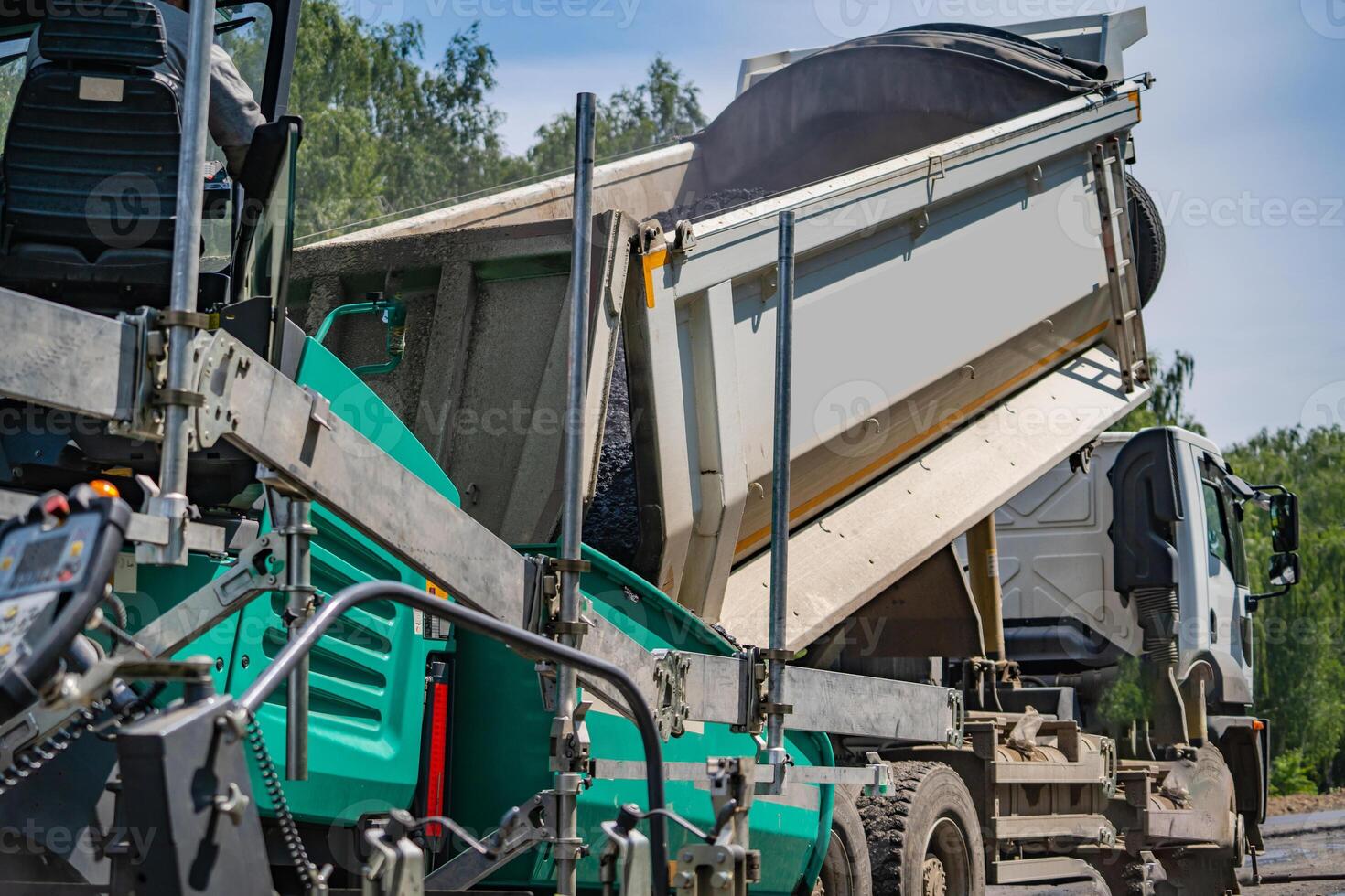 Flattering new asphalt at road. Selective focus on special machinery. Workers on blurred background. photo