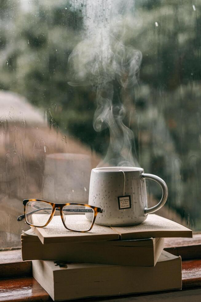 a cup of tea and glasses on a window sill photo