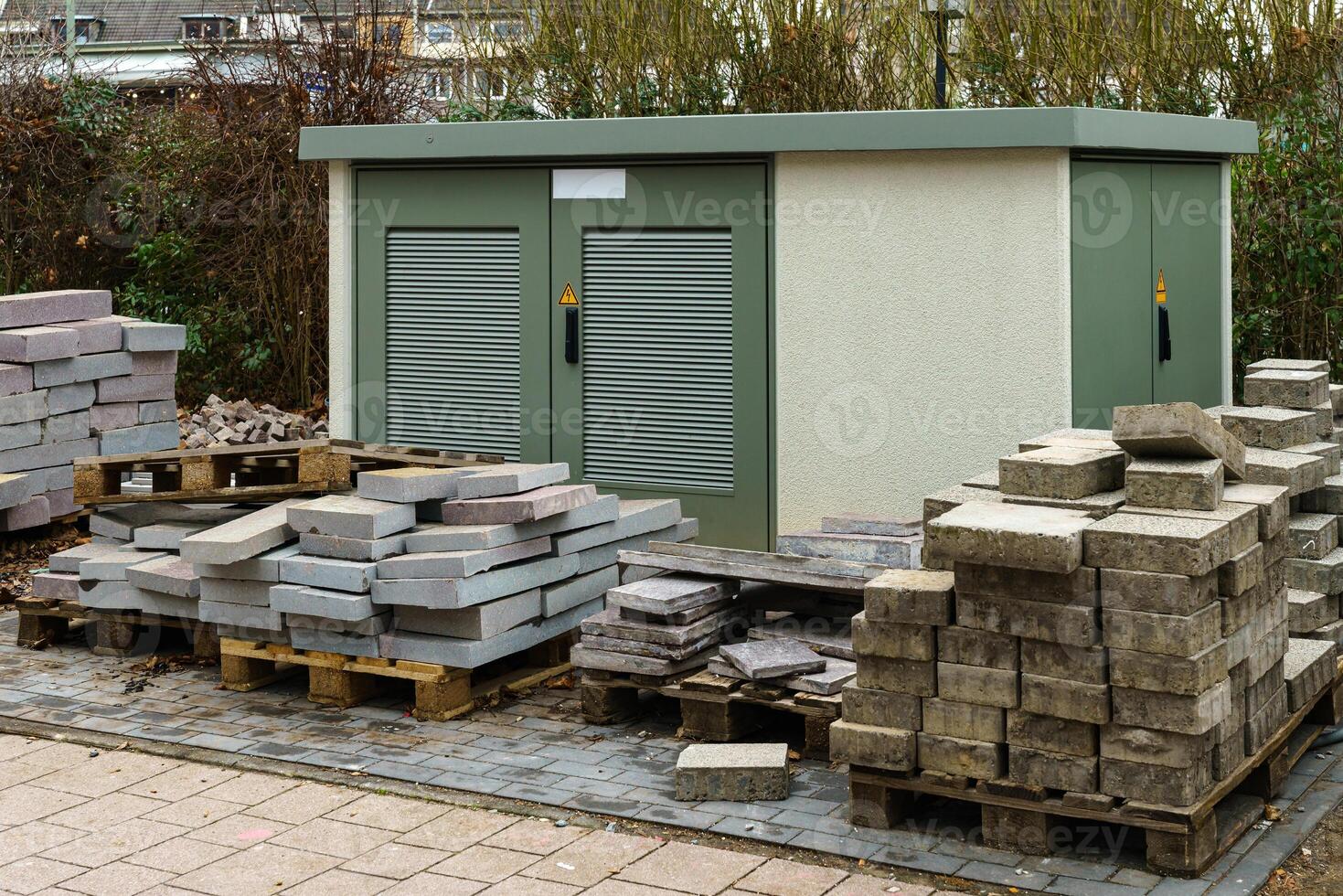Paving slabs on wooden pallets in front of the electric power transformer photo