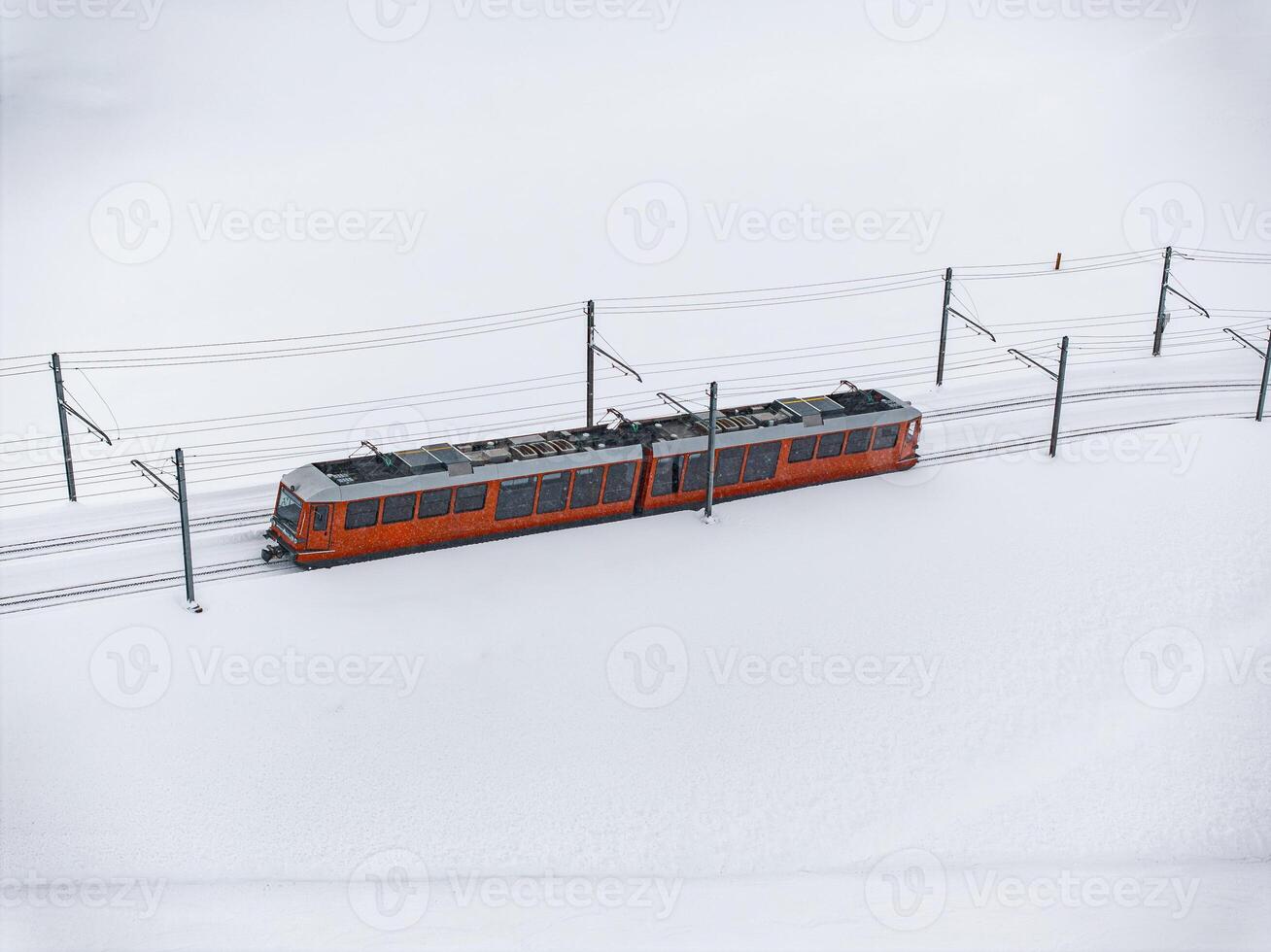 Bright Orange Train in Snowy Landscape, Zermatt Ski Resort Area Aerial View photo