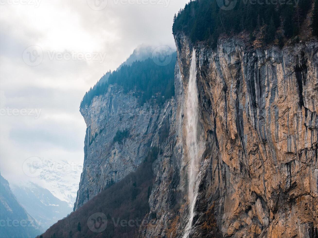 Stunning Waterfall Amidst Rugged Mountains in Murren, Switzerland. photo