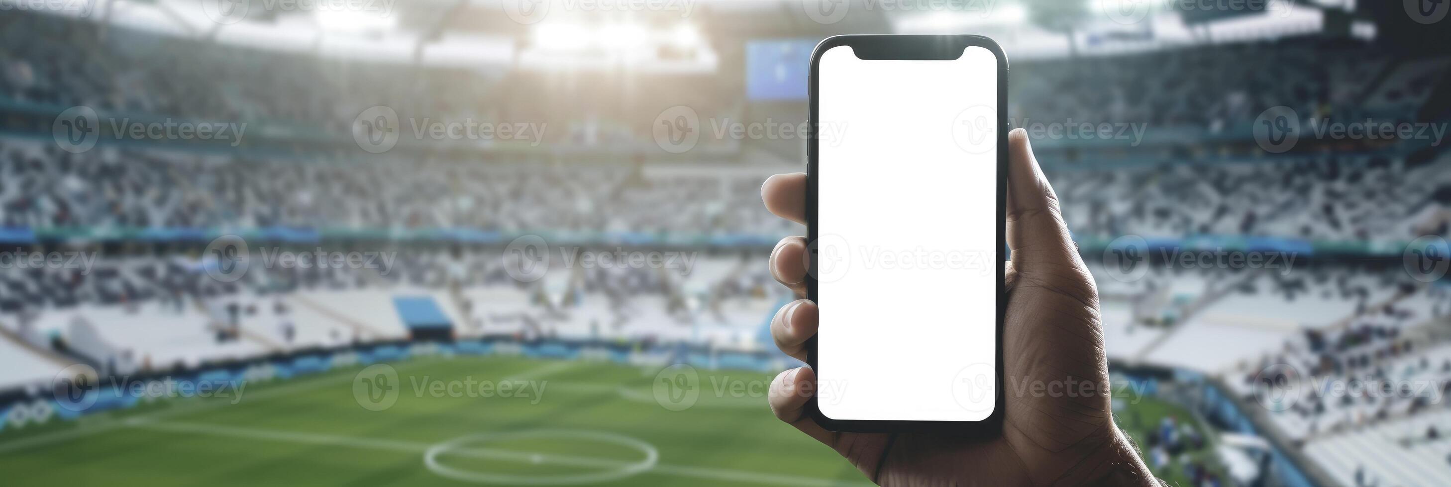 AI generated Hand Holding Smartphone with Blank White Screen Against Soccer or Football Stadium Background for Mockup Presentation photo