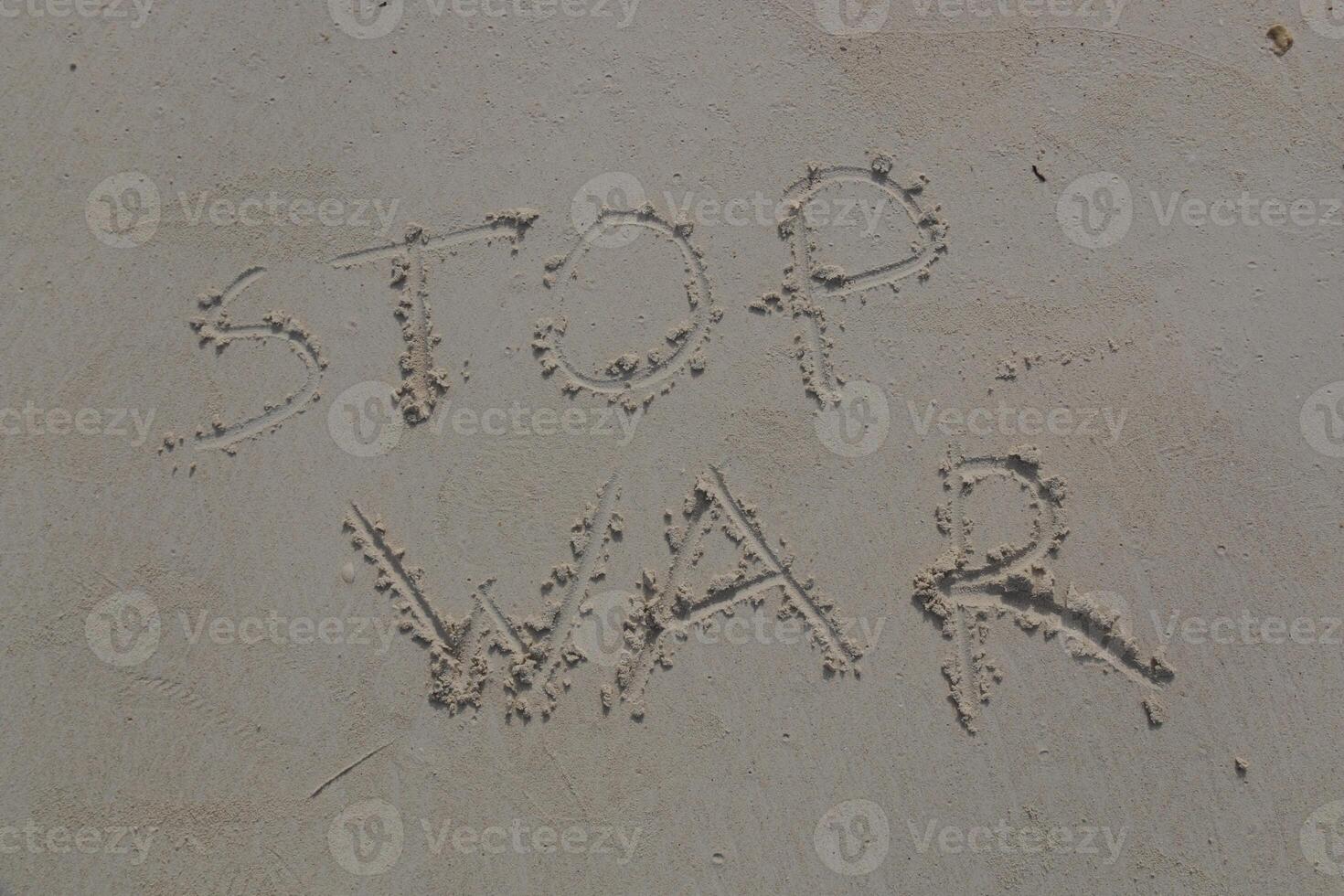 STOP WAR written on white sand photo