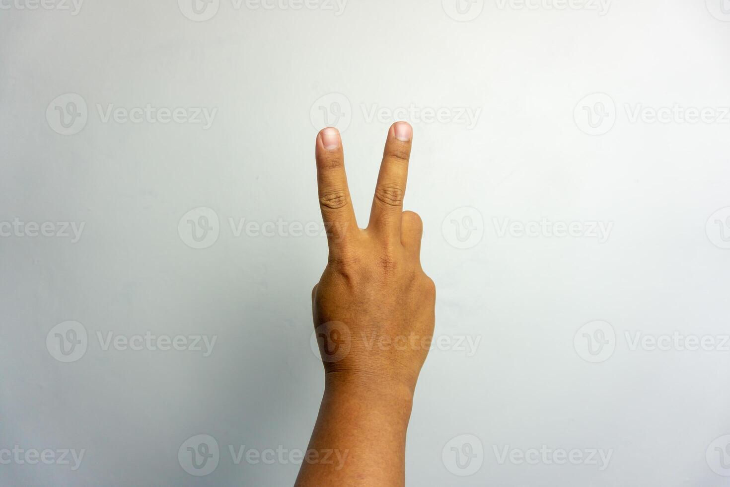 man hand number two gesture. number 2 hand sign isolated on white. peace hand sign. photo