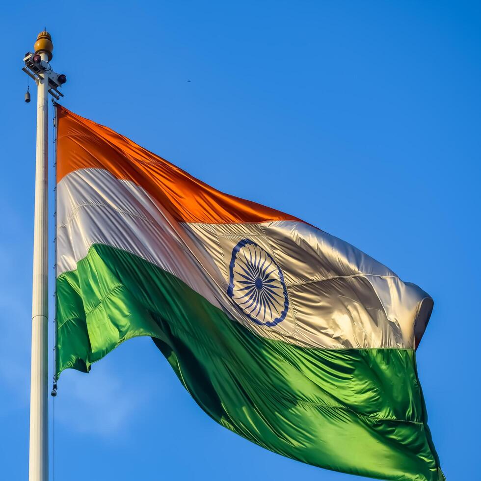 India flag flying high at Connaught Place with pride in blue sky, India flag fluttering, Indian Flag on Independence Day and Republic Day of India, tilt up shot, Waving Indian flag, Har Ghar Tiranga photo