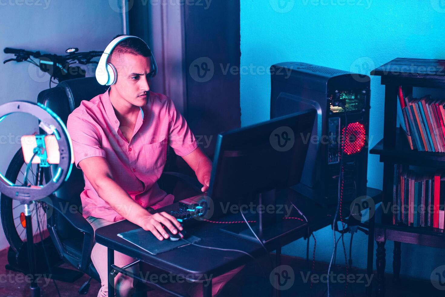 young latinx gamer man with headsets playing games on a computer. photo