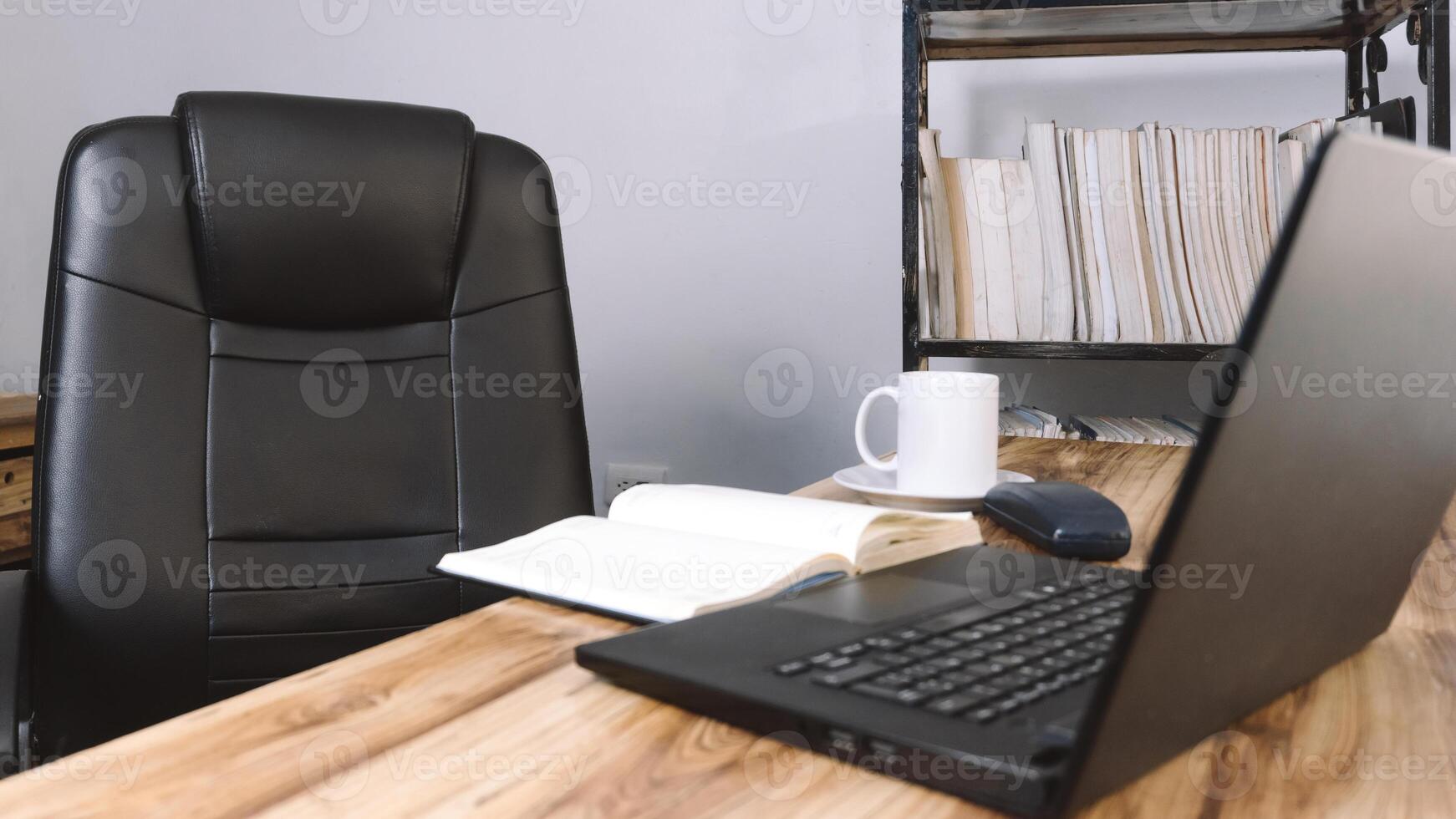 an office with a chair a desk a laptop a phone a notebook and a cup of coffee. concept background. photo