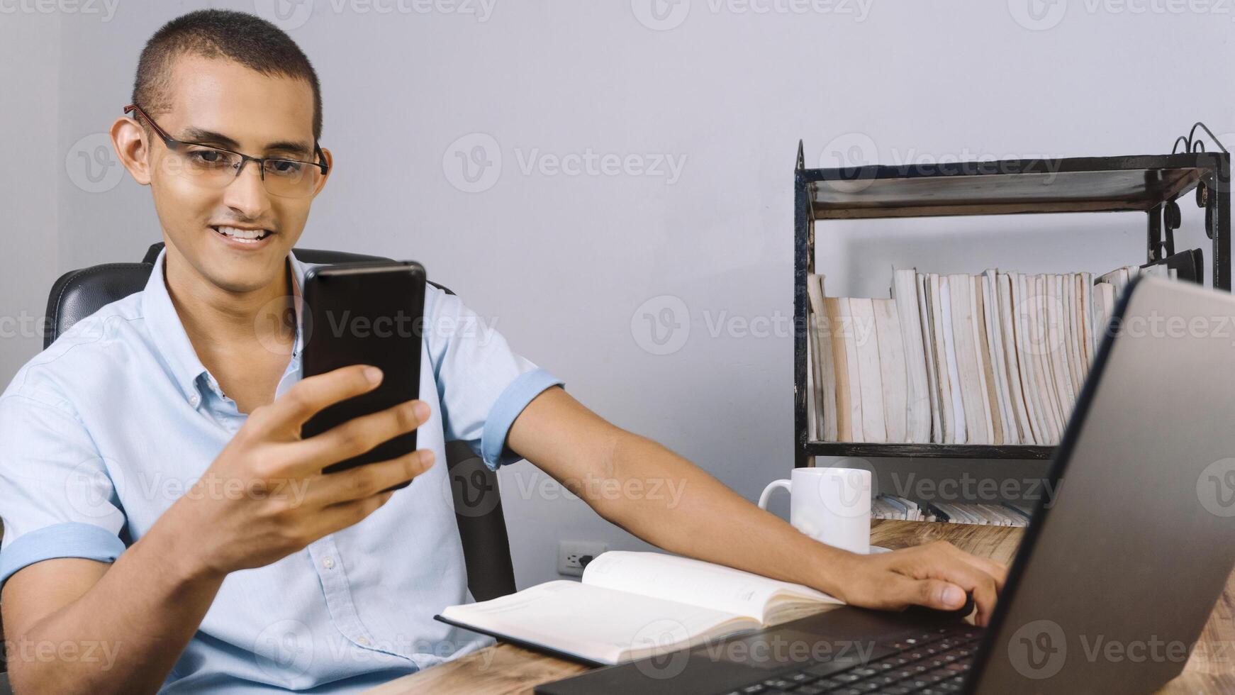young latinx looking at a mobile phone. technology concept. photo